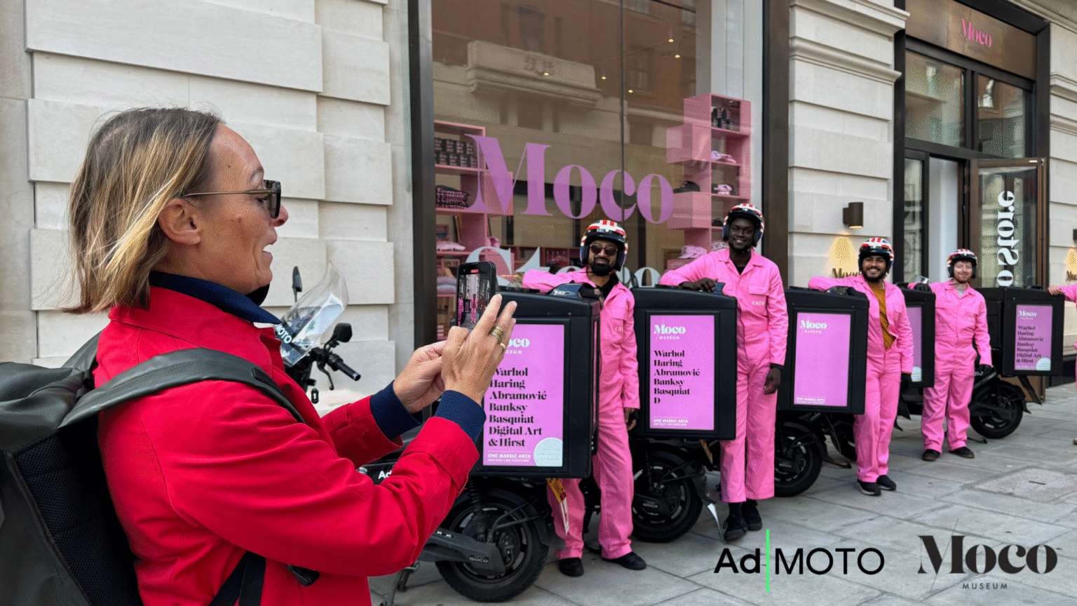 Passer-by photographing a line of Ad|MOTO riders and Ad|BOX screens in London, Ad|MOTO UK campaign